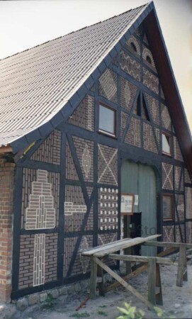 Hauptstraße 38: Bauernhaus: Teilansicht: straßenseitiger Giebel Wirtschaftstrakt mit Scheunentor: nach Renovierung: Ausmauerung der Gefache mit unterschiedlichen Mustern