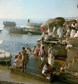 Ghats mit Badestellen. Pilger bei rituellen Handlungen. Blick auf den Ganges mit Booten