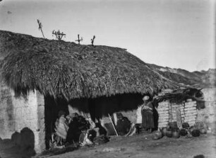 Schilf gedecktes Haus : Einige Menschen der indigenen Bevölkerung vor einem Haus bei Alto de Animas.