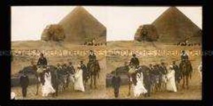 Reisegruppe auf Kamelen und Eseln vor Cheops-Pyramide und Sphinx in Gizeh
