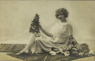 [Frau mit Puppe auf Knie]