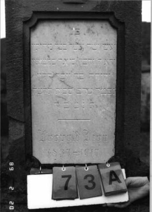 Grabstein 73 (Index: 99798573) Material: Sandstein, Schriftplatte Marmor Zustand: gut Maße HxBxT: 187x47x24 cm Beschreibung: Stele mit Volutenaufsatz, Schriftplatte, Sockel Symbolik: Kanne in Schale: Grabstein 73A