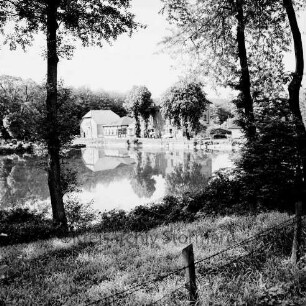 Lasbek-Gut: Lasbeker Mühle und Mühlenteich: vorn Wiese mit Bäumen: davor Zaun: im Hintergrund Bäume