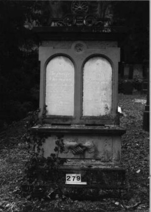 Grabstein 279 (Index: 100091581) Material: Sandstein; Schriftplatten:Marmor Zustand: gut Maße HxBxT: 224x102x40 cm Beschreibung: Doppelst. m. Abdeckplatte u. Aufsatz, getreppt. Sock/2 getrennte Schriftplatten Symbolik: Rosette, zwei sich schüttelnde Hände: Grabstein 279
