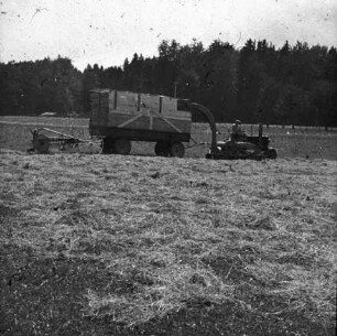 Fotografie: Heuernte, Feldhäcksler angebaut, Zweiachsanhänger, Schubrechwender