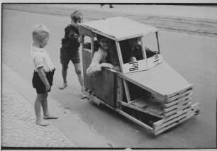Berlin. Spielende Kinder mit Eigenbau-Fahrzeug