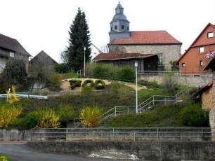 Diemerode-(Evangelische Kirche) - Ansicht von Süden mit Kirche über (einst wehrhafter) Kirchhofmauer in erhöhter Lage am Ortsrand