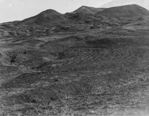 Hügellandschaft : Blick über Felder auf eine Hügelkette.