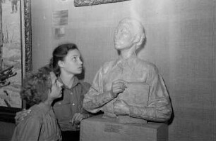 Ausstellung der Sowjetunion im Gebäude des Finanzministeriums der DDR am Werderschen Markt anlässlich der III. Weltfestspiele in Berlin : Ausstellungsbesucher vor einer Büste