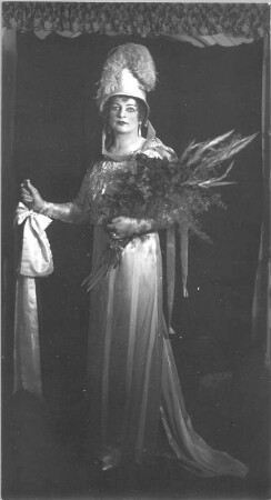 Meta Seinemeyer als Tosca : Meta Seinemeyer als Tosca in der gleichnamigen Oper von Giacomo Puccini. Staatsoper Dresden, Partie ab 6. April 1925 (ab 1. August 1925 Engagement). Ganzfigur mit Ehrenschleife und Blumenstrauß. Fotografie (Negativabzug auf Papier) von Ursula Richter