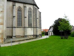 Kirche von Süden im Südsüdosten-gotisches Hochchor mit Strebepfeilern sowie Maßwerkfenstern über Kirchhof