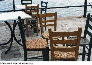 Stühle auf der Terrasse eines Restaurants am Meer