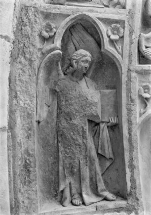 Südliches Westportal — Linke Archivolte — Engel mit geöffnetem Buch