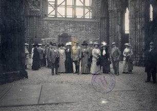 Edinburgh (Schottland). Touristen bei der Besichtigung von Holyrood Castle (wohl im Langhaus der Kirchenruine)