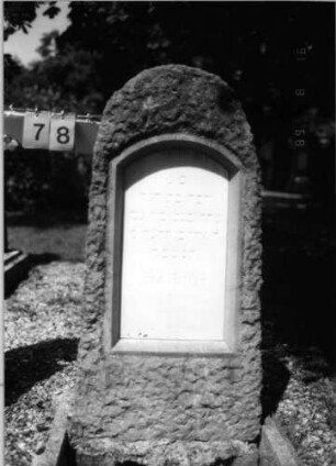 Grabstein 78 (Index: 100086546) Material: Granit mit weißer Marmorplatte Zustand: gut Maße HxBxT: 128x52x14 cm Beschreibung: grob stelenhaft behauener Stein, Schrifttafel mit Segmentbogen: Grabstein 78