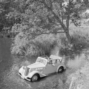 Personenkraftwagen Borgward Hansa 1100 Cabriolet mit offenem Verdeck in einem Gewässer, auf der Rückbank sitzt das Kind der Gremmlers