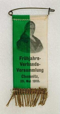 Bandabzeichen Frühjahrs-Verbandsversammlung Sächsischer Landesverband Gabelsberger in Chemnitz 1910 (mit Broschennadel) : Medaillensammlung Stenografische Sammlung. Bandabzeichen Bandabzeichen Frühjahrs-Verbandsversammlung Sächsischer Landesverband Gabelsberger in Chemnitz 1910 (grün-weißes Band mit Brustbild Gabelsbergers und Aufschrift "Frühjahrs-Verbands-Versammlung Chemnitz, 29. Mai 1910.", mit Broschennadel). Stoff; Maße (ohne Nadel) 81 x 31 mm (1910). Dresden: SLUB R c 0417