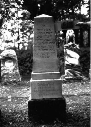 Grabstein 63 (Index: 100101509) Material: Marmor, unterster Sockelteil Kalkstein Zustand: gut Maße HxBxT: 155x42x21 cm Beschreibung: Obelisk, getreppter Sockel, unterster Sockelteil rusticaartig Steinmetz: J. Götz: Grabstein 63