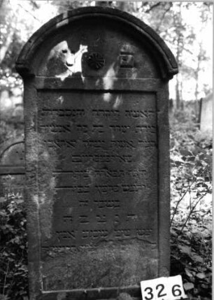 Grabstein 326 (Index: 99803506) Material: Sandstein Zustand: seitl. leicht verwitt/abgeblätt/Textverl Maße HxBxT: 130x58x12 cm Beschreibung: Stele m it verdachtem Rundbogen, profilierter Rand, Giebelfeld Symbolik: Stern: Grabstein 326