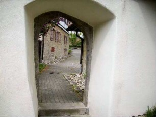 Kirchhof im Osten - Kirchhofmauer mit Mannpforte von Kirchhofseite mit spitzbogigem Gewände und Mauerstärke unter neuzeitlichem Verputz