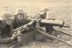 Drei Soldaten um ein Maschinengewehr (Nahaufnahme)