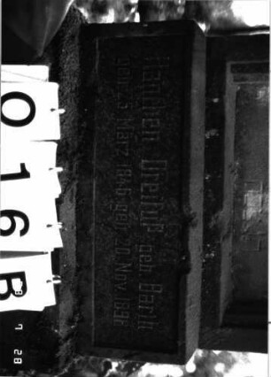 Grabstein 16 (Index: 100101164) Material: Sandstein mit schwarzer Granitplatte unten Zustand: gut Maße HxBxT: 154x51x22 cm Beschreibung: Stele, getreppter Sockel, getreppter Abschluß mit Kugelaufsatz, Schriftfeld mit Maßwerk Symbolik: Maßwerk: Grabstein 16B