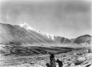 Westseite des Nevado de Chañi : Berglandschaft. Im Vordergrund Mann mit Hunden