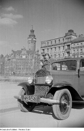 Porträt von Renate Rössing an einem Auto, im Hintergrund das Neue Rathaus