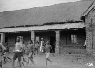 Missionsgebäude : Personen vor einem Missionsgebäude.