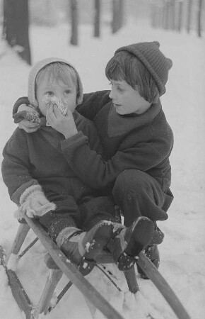Kinder beim Ski- und Schlittenfahren