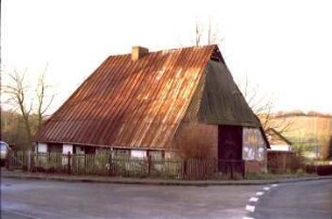 Sehmsdorf: Hofkamp 1: traufständige Fachwerkkate mit Blechdach: Straßenfront mit Eingangstür, links Wohntrakt: Giebelseite Wirtschaftstrakt mit Scheunentor: vorne rechts Einmündung in Dorfstraße