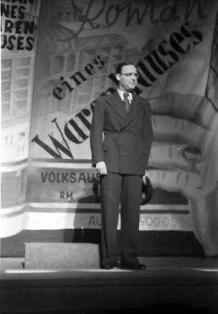 Berlin: Kabarett der Komiker; Walter Gross vor Warenhausprospekt
