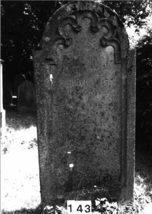 Grabstein 143 (Index: 100085463) Maße HxBxT: 140x65x16 cm Beschreibung: Stele, eingezog. Rundbogenabschl. , Schriftfeld eingetieft mit Maßwerk auf Vordersei: Grabstein 143