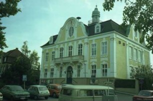 Paul-von-Schoenaich-Straße 14: Rathaus: Straßenfront: Mittelrisalit mit geschweiftem Giebel, über rundem Giebelfenster Giebelfeld mit Wappen: Freitreppe, Eingangsportal, Balkon: rechts Seitenfront zu Bergstraße: oben Dachreiter mit umlaufender Galerie, Sirene