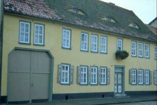 Haus mit vielen Fenstern und überbauter Torfahrt