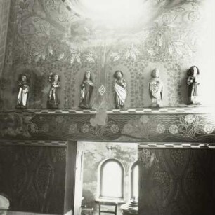 Heiligenfiguren vor Wandmalereien