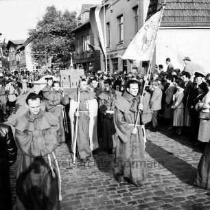 Karpfenfest: Umzug: Matthias-Claudius-Straße / Ahrensböker Straße (hinten): Fußgruppe, Abt und Mönche, mit Fahne und Modell der ehemaligen Klosterkirche: Zuschauer, Fahnenschmuck, Wimpelgirlanden, 13. Oktober 1957