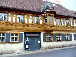 Stadtbild - Fachwerk-Bürgerhaus über Traufseite mit ornamentierter Holzschnitzerei sowie Fachwerk-Erker mit Zwiebelhaube