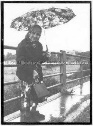 Ältere Dame mit Regenschirm und Handtasche (Altersgruppe 14-17)