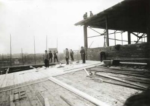 Güstrow, Speicherstraße. Baustelle Kongreßhalle. Zimmerleute beim Herstellen einer hölzernen Dachverschalung