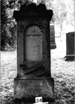 Grabstein 34 (Index: 100092760) Material: Sandstein Zustand: Schrift auf Sockel verwittert Maße HxBxT: 163x65x30 cm Beschreibung: Stele auf Sockel, Schriftfelder auf Stele und Sockel Symbolik: Blumenornamente, Schriftband: Grabstein 34