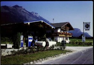 Schleching: Haus mit Blumenbalkon, mit Tankstelle und Pinguin [Auto]