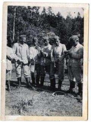Gruppenbild von Soldaten beim Knoten von Seilen