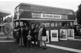 Freiburg: London-Bus auf Tournee am Karlsplatz, mit Singgruppe