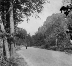 Unbefestigte Gebirgsstraße mit Wanderer