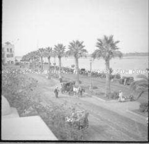 Passanten und Pferdedroschke auf einer Uferpromenade am Nil, Luxor, Ägypten
