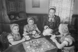 Schleifer Frauen und Mädchen beim Kaffeetrinken nach dem Verzieren von Ostereiern. : Holcy a žony w Slepjanskej drasće po debjenju jutrownych jejkow při kófejpiću pola Wěrikec w Rownom.