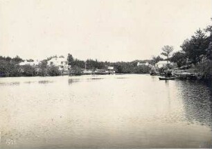 Bermudainseln. Küstenlandschaft. Blick in eine Bucht mit Bootsanlegestelle und hellen Wohnhäusern