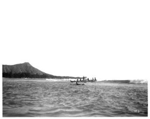 Honolulu-Waikiki. Männer in Booten beim Wellenreiten auf dem Pazifischen Ozean