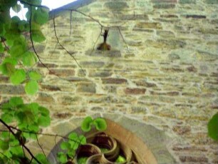 Langhaus Giebelseite West-Schießscharte (Steigbügelscharte) im romanischen Mauerwerk im Detail